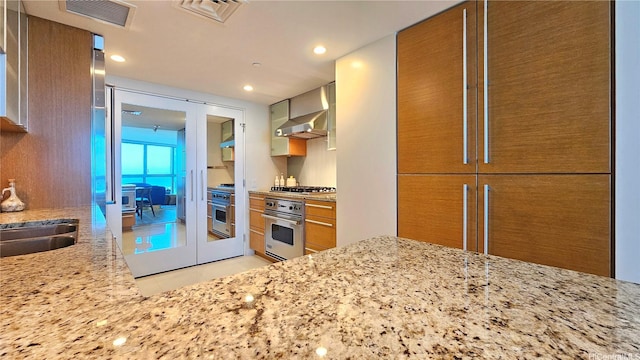 1177 Queen St Unit 1805, Honolulu, HI 96814 - kitchen featuring appliances with stainless steel finishes, light stone countertops, light tile patterned flooring, brown cabinets, and recessed lighting