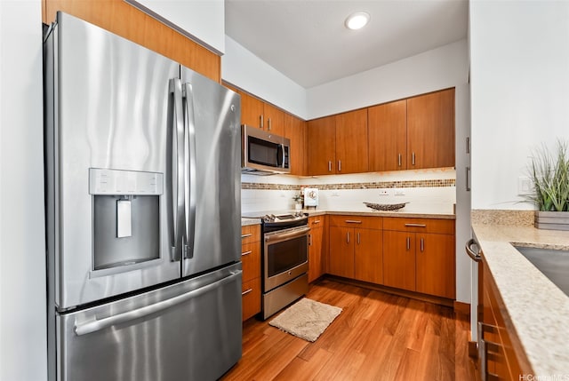 555 S St Unit 2303, Honolulu, HI 96813 - kitchen with stainless steel appliances, light wood-style flooring, backsplash, brown cabinets, and recessed lighting