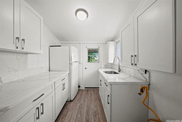 2963 Koali Rd Unit D, Honolulu, HI 96826 - kitchen with freestanding refrigerator, wood finished floors, light stone counters, tasteful backsplash, and white cabinetry