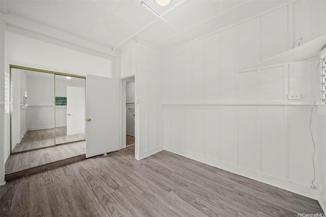 2963 Koali Rd Unit D, Honolulu, HI 96826 - unfurnished bedroom featuring a decorative wall, wood finished floors, and a closet