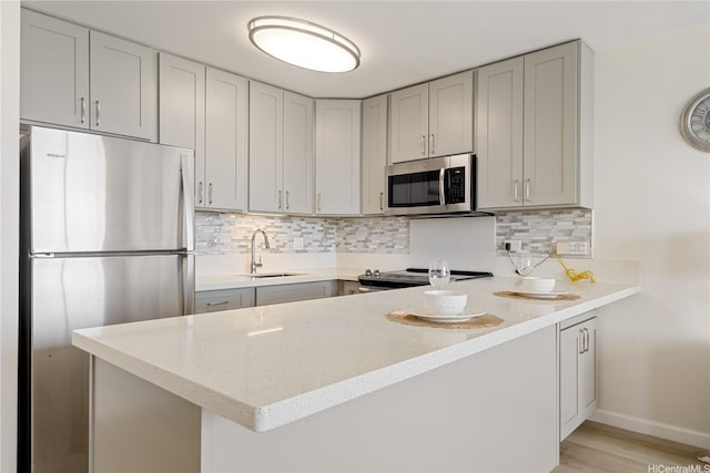 411 Hobron Ln Unit 3402, Honolulu, HI 96815 - kitchen featuring appliances with stainless steel finishes, a peninsula, tasteful backsplash, and light stone countertops