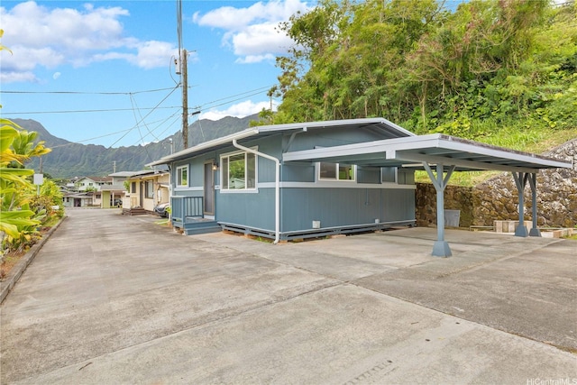 45-860 Anoi Rd Unit 5, Kaneohe, HI 96744 - view of front facade with concrete driveway, a mountain view, and a carport