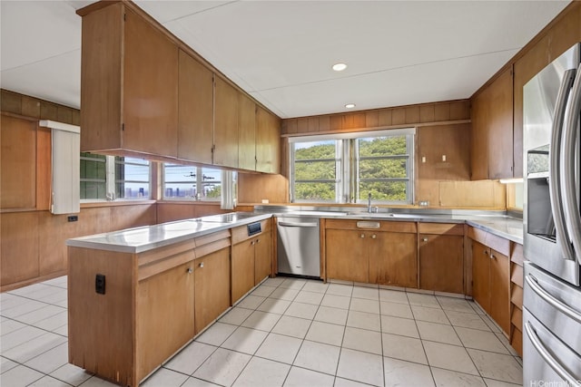 2316 Round Top Dr, Honolulu, HI 96822 - kitchen featuring stainless steel appliances, stainless steel countertops, a peninsula, brown cabinets, and wooden walls