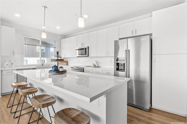 91-3575 Iwikuamoo St Unit 501, Ewa Beach, HI 96706 - kitchen featuring stainless steel appliances, light wood finished floors, backsplash, a kitchen bar, and recessed lighting