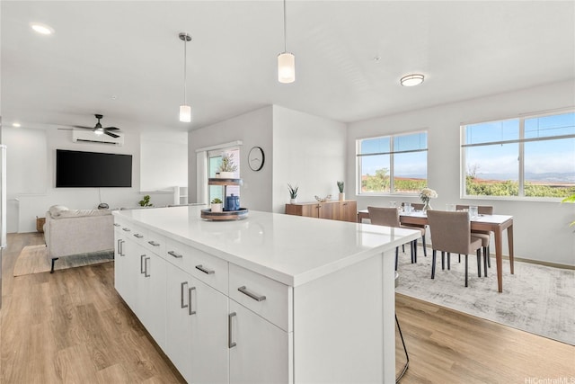 91-3575 Iwikuamoo St Unit 501, Ewa Beach, HI 96706 - kitchen featuring light wood finished floors, a center island, a ceiling fan, hanging light fixtures, and light countertops