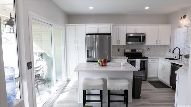 91-950 Laaulu St Unit 42E, Ewa Beach, HI 96706 - kitchen with appliances with stainless steel finishes, white cabinetry, tasteful backsplash, light stone counters, and recessed lighting