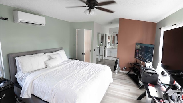 91-950 Laaulu St Unit 42E, Ewa Beach, HI 96706 - bedroom with a wall unit AC, light wood-style floors, vaulted ceiling, an office area, and ensuite bath