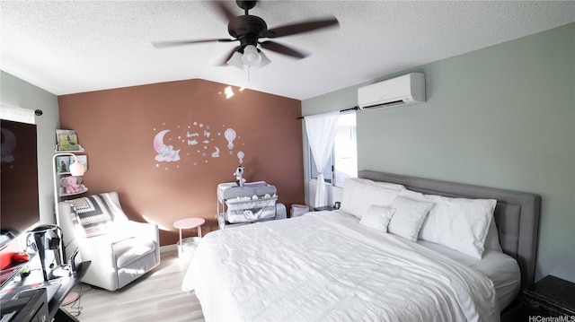 91-950 Laaulu St Unit 42E, Ewa Beach, HI 96706 - bedroom with a wall mounted AC, light wood finished floors, vaulted ceiling, a textured ceiling, and a ceiling fan