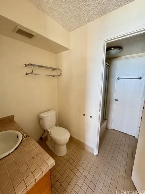 1676 Ala Moana Blvd Unit 1007, Honolulu, HI 96815 - bathroom with tile patterned floors, a shower stall, a textured ceiling, and vanity