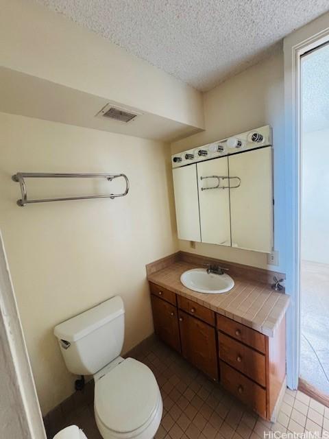 1676 Ala Moana Blvd Unit 1007, Honolulu, HI 96815 - half bathroom featuring vanity, a textured ceiling, and tile patterned flooring