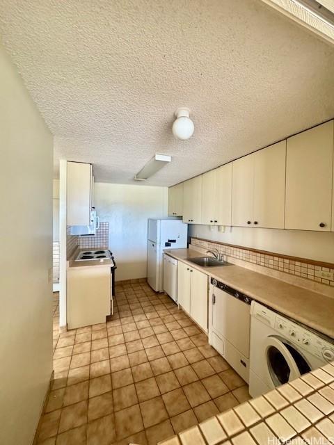 1676 Ala Moana Blvd Unit 1007, Honolulu, HI 96815 - kitchen featuring washer / dryer, dishwasher, white cabinets, light countertops, and freestanding refrigerator