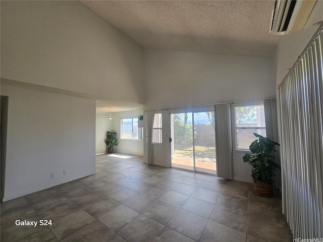 94-1060 Lelehu St, Waipahu, HI 96797 - empty room featuring a high ceiling, a textured ceiling, and dark tile patterned flooring