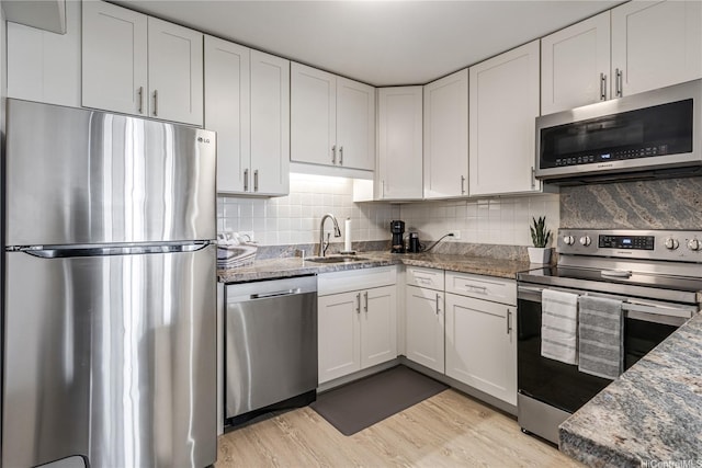 1860 Ala Moana Blvd Unit 1208, Honolulu, HI 96815 - kitchen featuring stainless steel appliances, white cabinets, decorative backsplash, and light wood-style flooring