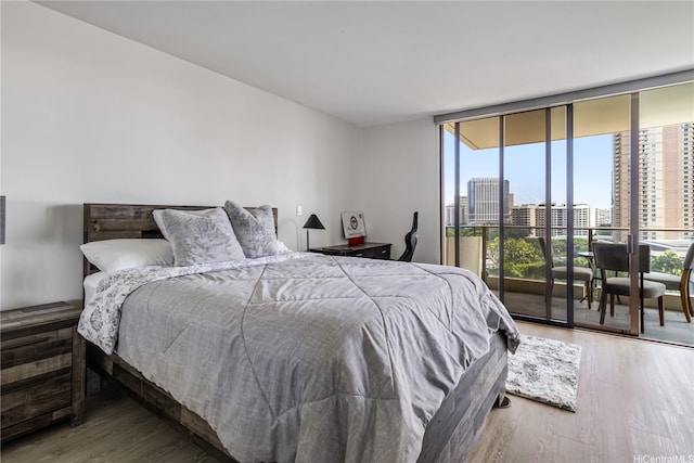 1860 Ala Moana Blvd Unit 1208, Honolulu, HI 96815 - bedroom featuring access to exterior, a view of city, wood finished floors, and a wall of windows