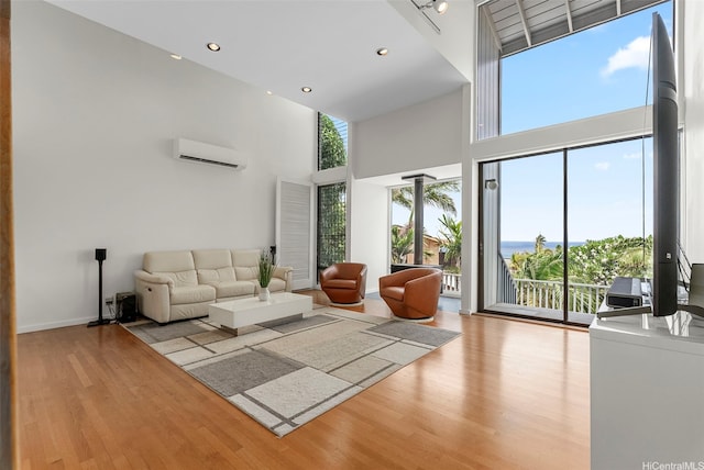 1789 Laukahi St, Honolulu, HI 96821 - living room featuring a wall mounted AC, a towering ceiling, wood finished floors, and recessed lighting