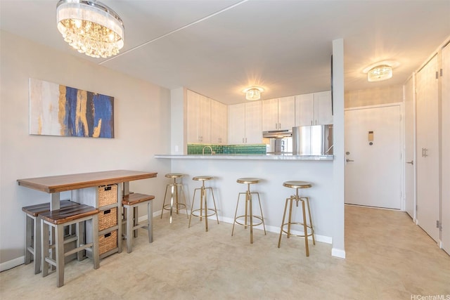 400 Hobron Ln Unit 2809, Honolulu, HI 96815 - kitchen with freestanding refrigerator, a breakfast bar, a chandelier, light countertops, and a peninsula