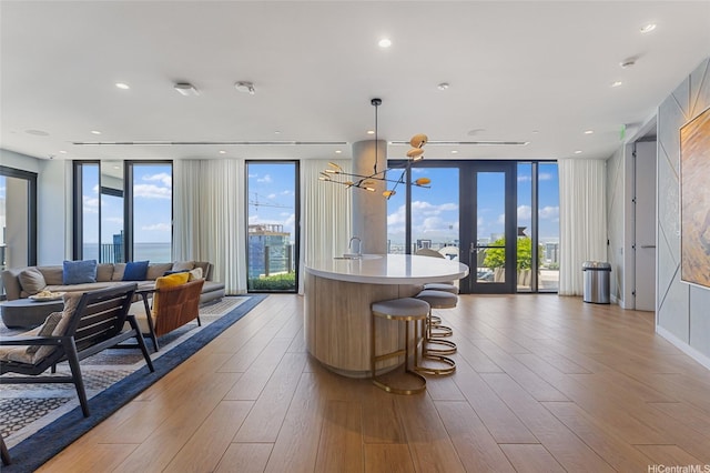 987 Queen St Unit 3209, Honolulu, HI 96814 - kitchen with open floor plan, floor to ceiling windows, light countertops, a chandelier, and a kitchen island with sink
