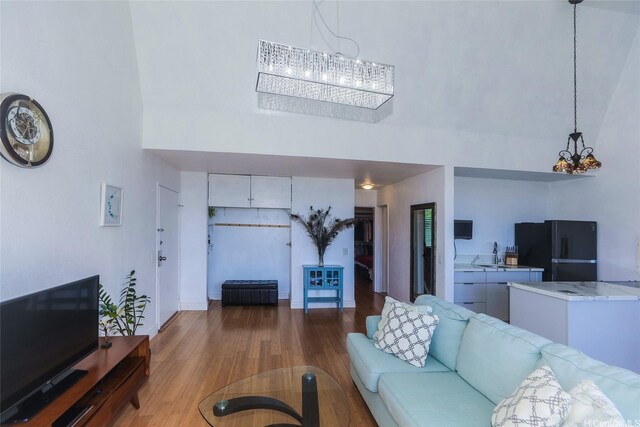 84-718 Ala Mahiku St Unit 21/97C, Waianae, HI 96792 - living room with a high ceiling, a chandelier, and wood finished floors