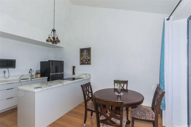 84-718 Ala Mahiku St Unit 21/97C, Waianae, HI 96792 - dining room featuring light wood-style floors, a chandelier, and a high ceiling