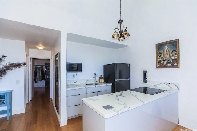 84-718 Ala Mahiku St Unit 21/97C, Waianae, HI 96792 - kitchen featuring black appliances, modern cabinets, light wood finished floors, a peninsula, and a chandelier
