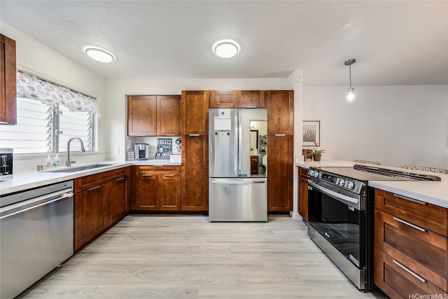 91-630 Kilaha St Unit 1, Ewa Beach, HI 96706 - kitchen with appliances with stainless steel finishes, light wood-style floors, light countertops, hanging light fixtures, and brown cabinetry