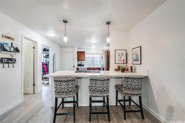 91-630 Kilaha St Unit 1, Ewa Beach, HI 96706 - kitchen with a peninsula, light wood-style floors, light countertops, and a breakfast bar