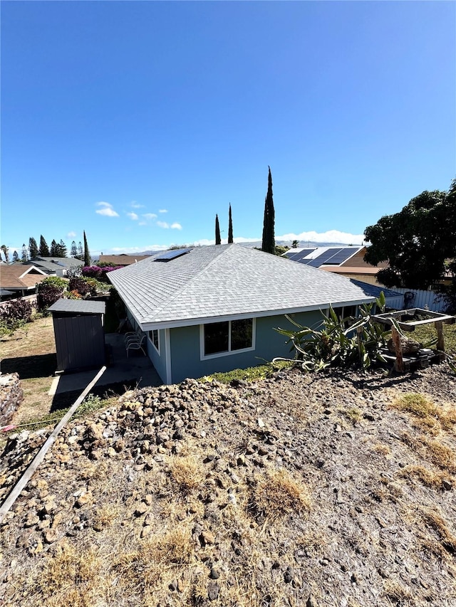 68-3521 E Makuahine St, Waikoloa, HI 96738 - view of side of property with roof mounted solar panels and roof with shingles