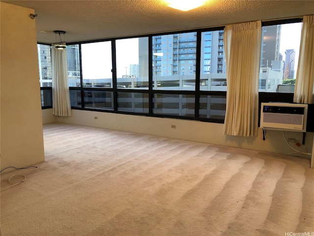 876 Curtis St Unit 1406, Honolulu, HI 96813 - unfurnished room featuring a city view, carpet floors, a wall mounted AC, plenty of natural light, and a textured ceiling