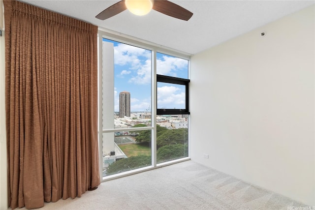 1212 Nuuanu Ave Unit 1104, Honolulu, HI 96817 - spare room with a wall of windows, carpet, a ceiling fan, and a view of city
