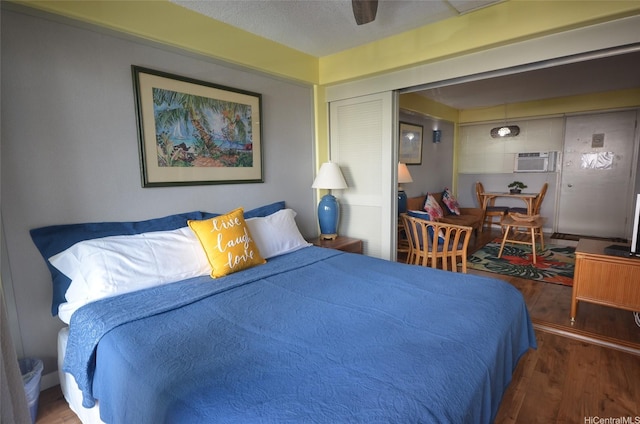 417 Nohonani St Unit 405, Honolulu, HI 96815 - bedroom featuring wood finished floors, a wall unit AC, and a ceiling fan