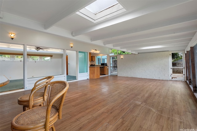 44-151 Bayview Haven Pl, Kaneohe, HI 96744 - living area featuring healthy amount of natural light, beam ceiling, brick wall, wood finished floors, and a skylight