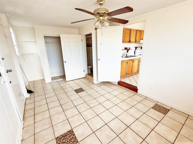 91-1206 Hanaloa St, Ewa Beach, HI 96706 - kitchen featuring ceiling fan, light countertops, brown cabinetry, and light tile patterned floors