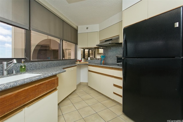 1221 Victoria St Unit 2301, Honolulu, HI 96814 - kitchen with freestanding refrigerator, under cabinet range hood, backsplash, light tile patterned floors, and a textured ceiling