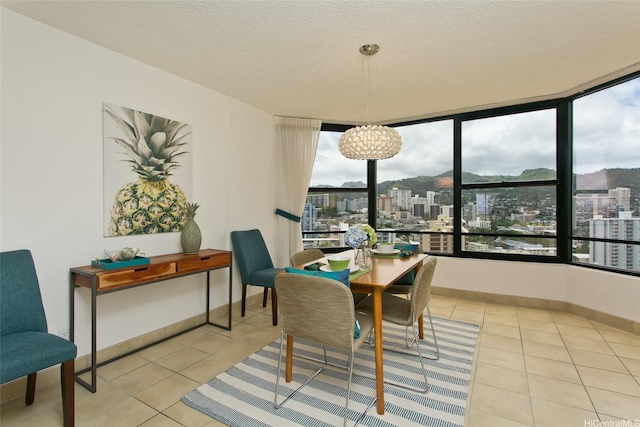 1221 Victoria St Unit 2301, Honolulu, HI 96814 - tiled dining space with plenty of natural light, a chandelier, a city view, and a textured ceiling