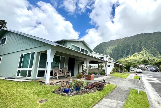 47-643 Hui Ulili St, Kaneohe, HI 96744 - view of property exterior featuring a mountain view, driveway, a lawn, and covered porch