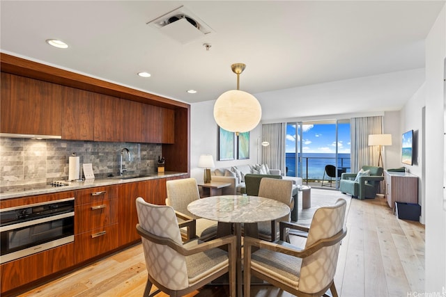 383 Kalaimoku St Unit 3109, Honolulu, HI 96815 - dining room featuring bar with sink, light wood-style floors, and recessed lighting