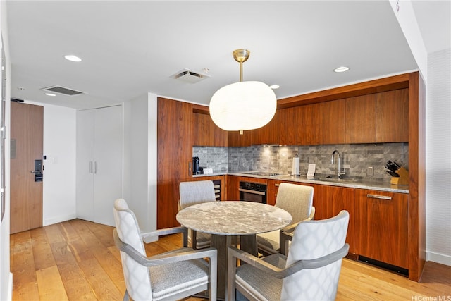 383 Kalaimoku St Unit 3109, Honolulu, HI 96815 - kitchen featuring brown cabinetry, light countertops, and recessed lighting