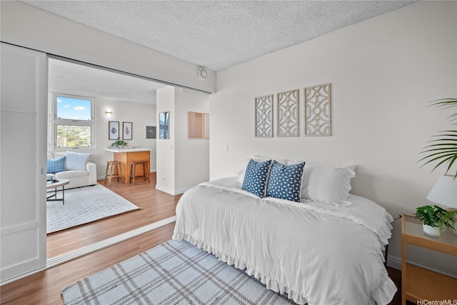 2754 Kuilei St Unit 1601, Honolulu, HI 96826 - bedroom with wood finished floors, a textured ceiling, and ensuite bathroom