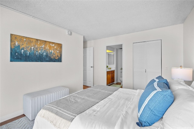 2754 Kuilei St Unit 1601, Honolulu, HI 96826 - bedroom featuring a textured ceiling, connected bathroom, a closet, and wood finished floors