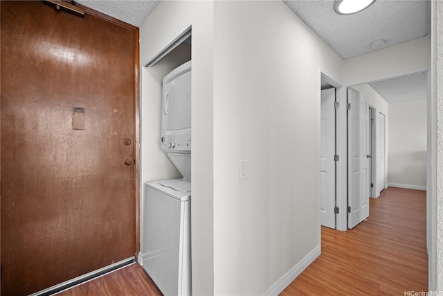 2754 Kuilei St Unit 1601, Honolulu, HI 96826 - laundry area with stacked washing machine and dryer, light wood-type flooring, and a textured ceiling