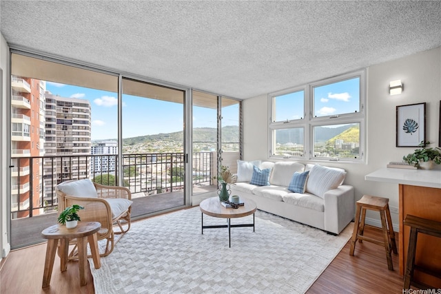 2754 Kuilei St Unit 1601, Honolulu, HI 96826 - living area with a wall of windows, wood finished floors, and a textured ceiling
