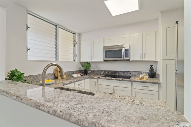 469 Ena Rd Unit 3208, Honolulu, HI 96815 - kitchen featuring stainless steel appliances, white cabinetry, and light stone countertops