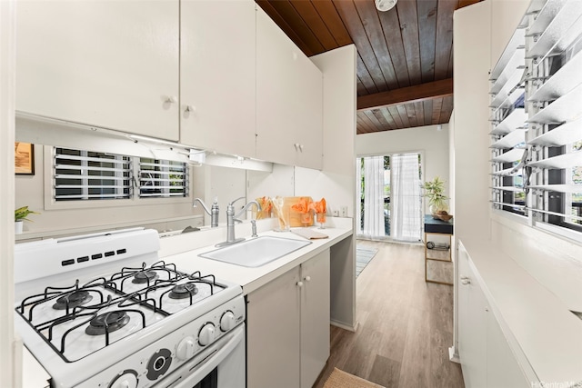 222 Kawaikui Pl, Honolulu, HI 96821 - kitchen with a wooden ceiling with exposed beams, white gas range oven, light wood-type flooring, and light countertops