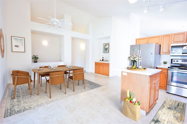 94-1043 Alelo St, Waipahu, HI 96797 - kitchen with stainless steel appliances, light countertops, rail lighting, a ceiling fan, and a kitchen island