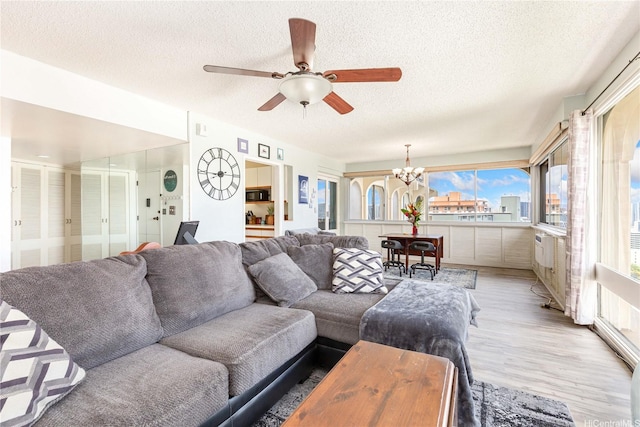 1022 Prospect St Unit 704A, Honolulu, HI 96822 - living room with plenty of natural light, a textured ceiling, a chandelier, light wood finished floors, and ceiling fan