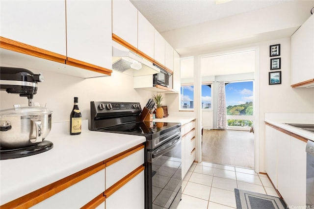 1022 Prospect St Unit 704A, Honolulu, HI 96822 - kitchen featuring black electric range, white cabinets, light countertops, light tile patterned flooring, and under cabinet range hood