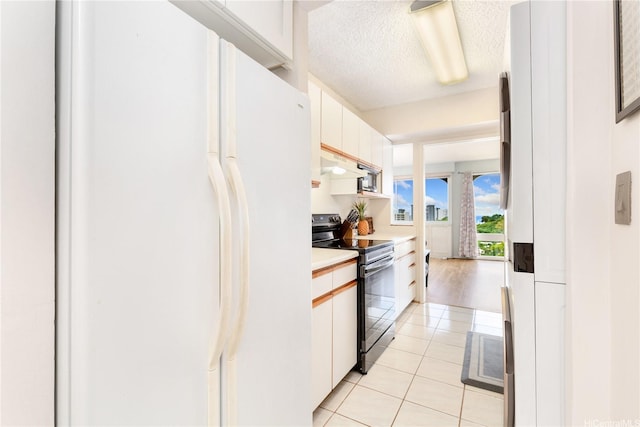 1022 Prospect St Unit 704A, Honolulu, HI 96822 - kitchen featuring freestanding refrigerator, electric range, light countertops, light tile patterned floors, and under cabinet range hood