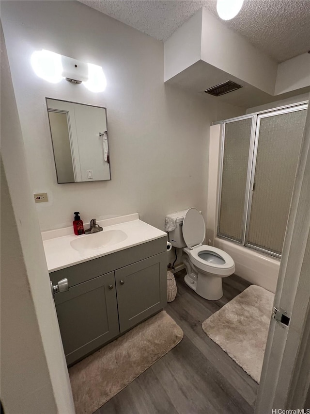 1616 Kewalo St Unit 303, Honolulu, HI 96822 - full bath with a textured ceiling, vanity, wood finished floors, and bath / shower combo with glass door