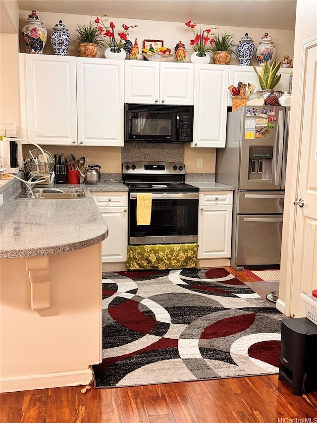 91-1200 Keaunui Dr Unit 309, Ewa Beach, HI 96706 - kitchen with stainless steel appliances, white cabinetry, and wood finished floors