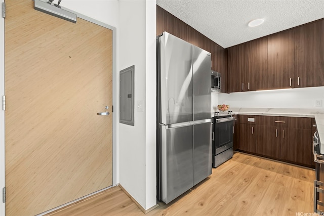 615 Keawe St Unit 3005, Honolulu, HI 96813 - kitchen with appliances with stainless steel finishes, electric panel, dark brown cabinets, a textured ceiling, and light wood-type flooring